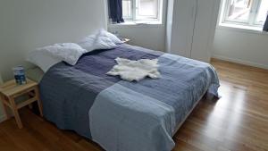 a bed with a white animal laying on top of it at Bakkegata - The blue House in Odda