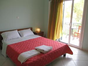 una camera da letto con un letto con due asciugamani sopra di Ammodares a Lixouri