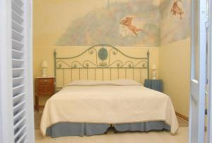 1 dormitorio con 1 cama y una pintura en la pared en Posada del Angel, en Colonia del Sacramento