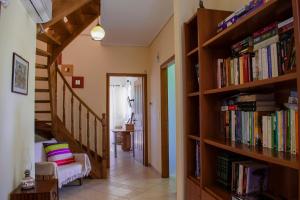 einen Flur mit Bücherregalen gefüllt mit Büchern in der Unterkunft Anavyssos Cottage in Palaia Fokaia