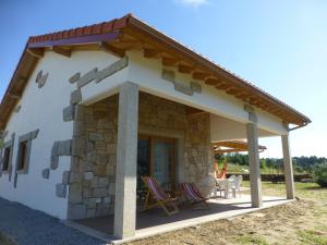 ein kleines Steinhaus mit zwei Stühlen und einer Terrasse in der Unterkunft Casa Retiro de Lisei in Penalva do Castelo