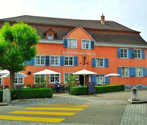 un grande edificio arancione con un cartello di fronte di Gasthaus Ochsen a Tägerwilen