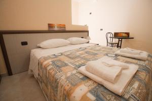 a bedroom with a bed with towels on it at B&B Ghiaccio in Gallipoli