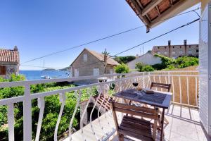 a patio with a table and chairs on a balcony at Apartman Prošperino in Vis