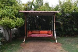 a couch in a swing in a garden at Modern Villa One in Lonavala