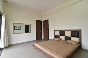 a bedroom with a bed and a mirror on the wall at Modern Villa One in Lonavala
