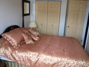 een slaapkamer met een bed met roze lakens en kussens bij Ashton Apartments in St. John's