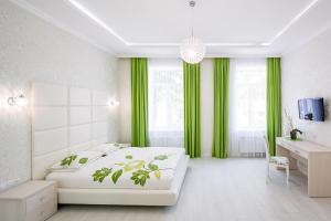 a bedroom with a white bed and green curtains at Crystal Apartments in Lviv