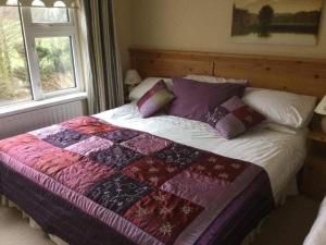 a bed with a quilt on it in a bedroom at Hillview House in Cootehill