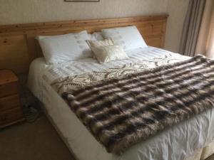 a bed with a large blanket on top of it at Hillview House in Cootehill