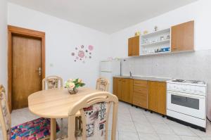 a kitchen with a wooden table and a white stove at Apartments Helena in Ivan Dolac