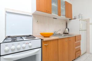 伊萬多拉克的住宿－Apartments Helena，厨房配有白色炉灶和白色冰箱。