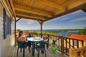 a woman sitting at a table on the deck of a house at Orsera Camping Resort by Valamar in Vrsar