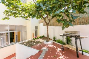 a tree in the middle of a courtyard with a table at Belém Vintage with Superb Private Terrace in Lisbon