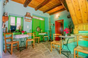 a room with tables and chairs and green walls at Morfeas Guesthouse in Papingo
