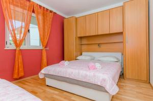 a bedroom with red walls and a bed with two pink towels at Apartments Mateo in Baška Voda