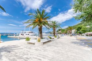 a street with palm trees and a boat at Apartments Mateo in Baška Voda