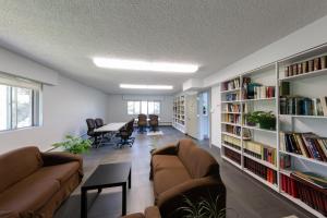 HI Edmonton - Hostel في إيدمونتون: غرفة معيشة مع اثنين من الأرائك وأرفف الكتب