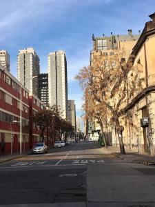 an empty street in a city with tall buildings at Moneda Express Apart in Santiago