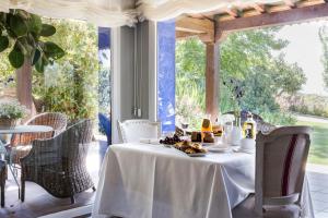 una mesa con un mantel blanco y comida en ella en Lalisea, en Talaveruela