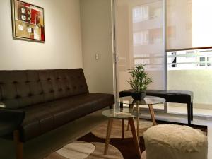 Moneda Express Apart في سانتياغو: غرفة معيشة مع أريكة وطاولة
