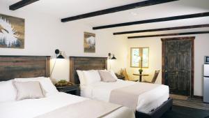 艾許福德的住宿－天堂村酒店，卧室设有2张床和白色的墙壁。