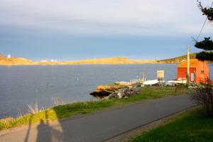 a road next to a body of water with a house at Kelly's Landing in Trinity