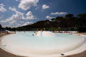 a large swimming pool with people in the water at Fabulous village in Casal Palocco