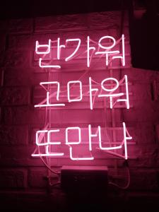 a neon sign that says happy hour at Take 1 Guesthouse Hongdae in Seoul