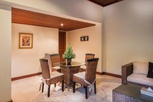 Samhita Garden Ubud في أوبود: غرفة طعام مع طاولة وكراسي وأريكة