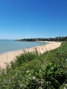 a view of a beach with people in the water at La salamandre, Chambre d'hôtes in Étaules