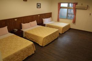 a hotel room with two beds and a window at Qingxiu Hotel in Baihe