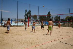 a group of men playing volleyball on a beach at Fabulous village in Casal Palocco