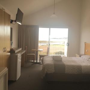 a hotel room with a bed and a balcony at A Great Ocean View Motel in Apollo Bay