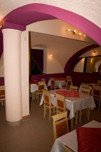 a restaurant with tables and chairs and purple ceilings at Apartments Klanac in Osijek