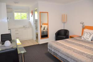 a hotel room with a bed and a bathroom at Culburra Beach Motel in Culburra Beach