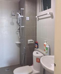 a bathroom with a shower and a toilet and a sink at Syafiq Suite in Kota Bharu