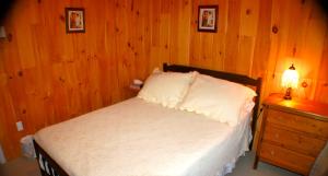 a bedroom with a bed and a wooden wall at Trinity Suites in Trinity