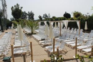 a group of white chairs and umbrellas at Fabulous village in Casal Palocco