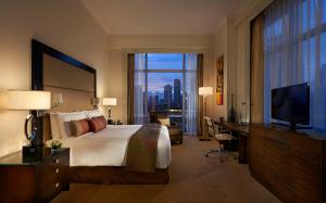 Una habitación de hotel con una cama grande y un televisor. en Fairmont Makati, en Manila