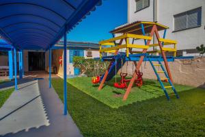 a playground with a slide in a yard at Pousada da Costa in Caraguatatuba