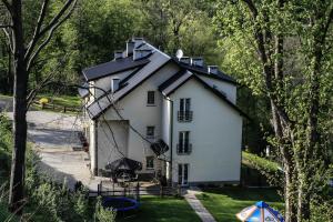 uma pequena casa branca com um telhado preto em Pensjonat Irena em Muszyna