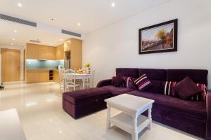 a living room with a purple couch and a table at The Ocean Apartment IDCWH B302 in Danang