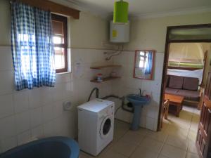 een kleine badkamer met een wasmachine bij Bikeventures House Uganda in Jinja