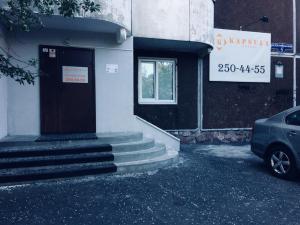 a door of a building with a car parked outside at Kapsula Hostel in Krasnoyarsk