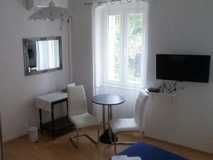 a living room with a table and chairs and a television at Family House Nerezine in Nerezine