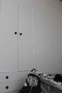 ザンブジェイラ・ド・マールにあるSigmaApartmentの白いキャビネットとソファ付きのベッドルーム1室