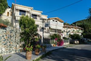 a building with potted plants on the side of a street at Studios Koukis in Kitriaí