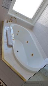 a bath tub in a bathroom with a window at Largs Pier Hotel in Adelaide