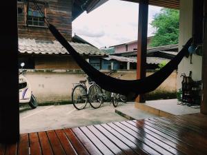 a hammock on a porch with two bikes parked at Baan Mai Sak in Pai